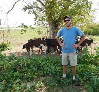 Reed Fitton with cattle and a tree behind him